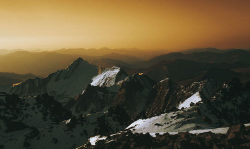 Scenic view of snowcapped mountains against sky during sunset