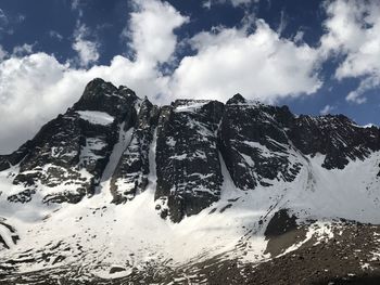 Low angle view of snowcapped mountains against sky