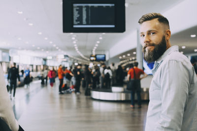 Portrait of smiling businessman standing with businesswoman at airport