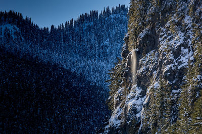 Snow falling down the side of mountain