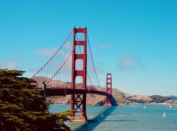 Golden gate bridge over river against blue sky