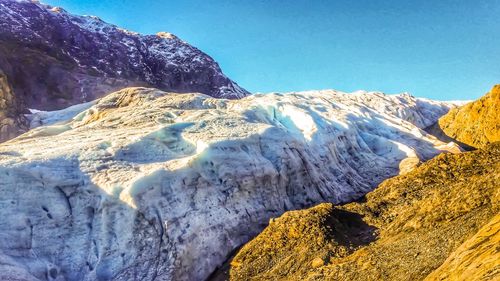 Scenic view of snowcapped mountains against clear blue sky