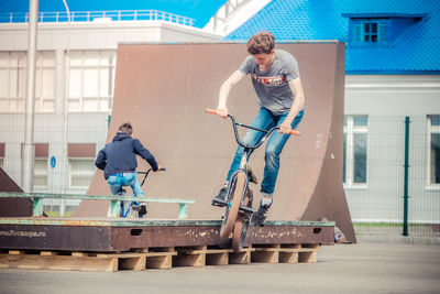 Friends riding bicycles at playground in city