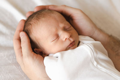 Close-up of baby boy sleeping on bed at home