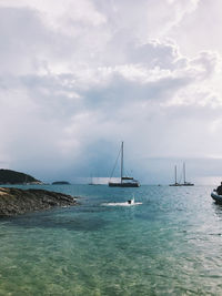 Sailboats sailing in sea against sky