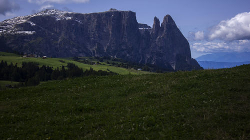 Scenic view of green landscape and mountains against sky 