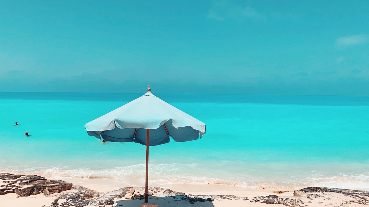 water, land, sea, beach, ocean, sky, umbrella, beauty in nature, nature, scenics - nature, parasol, tranquility, sand, vacation, trip, horizon over water, tranquil scene, summer, travel destinations, sunshade, holiday, beach umbrella, blue, horizon, travel, idyllic, relaxation, shore, coast, environment, copy space, sunlight, shade, no people, chair, outdoors, sunny, tourism, day, turquoise colored, sun, tropical climate, body of water, island, protection, wave, clear sky, cloud, coastline, bay, landscape