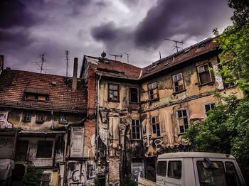 Abandoned house against sky in city