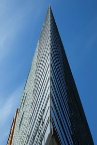 Low angle view of modern building against blue sky