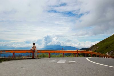 Rear view of a man overlooking road