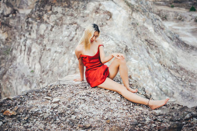 Young woman sitting on rock