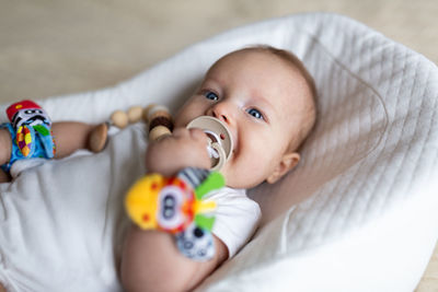 Portrait of cute baby girl lying on bed at home