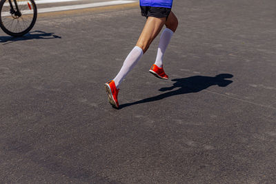 Low section of man skateboarding on road