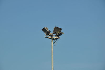 Low angle view of windmill against clear blue sky