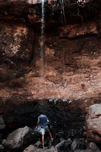 Rear view of people standing on rock