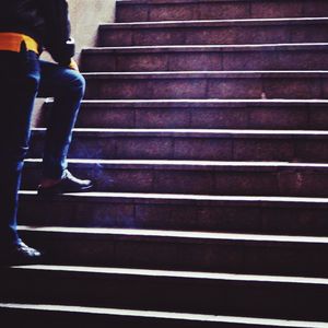 Low section of man walking on stairs