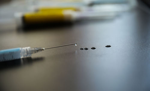 Close-up of syringe on table