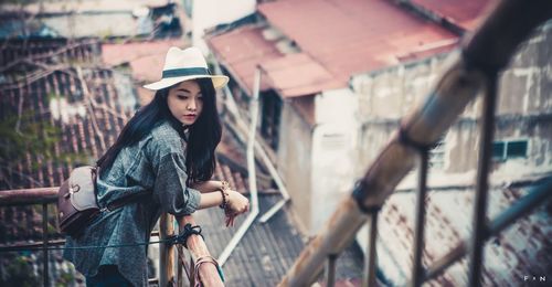 Portrait of woman standing by railing