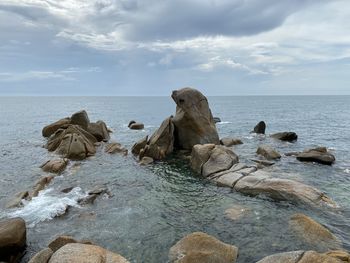 Rocks on sea shore against sky