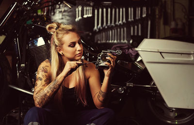 Woman repairing motorcycle at workshop