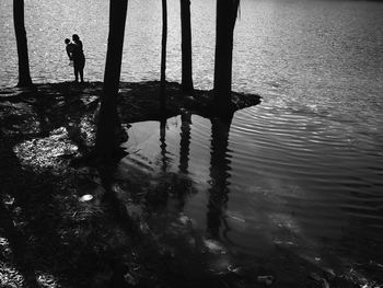 Silhouette man standing on beach against sky