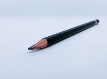 Close-up of pen on table against white background