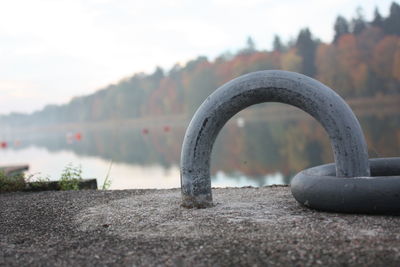 Close-up of metal railing against river