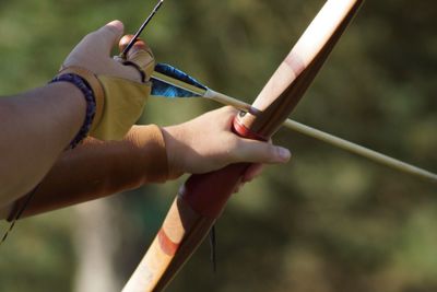 Cropped image of person holding archery bow