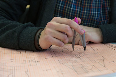 Close-up of man holding hands on table