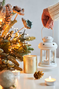 The girl's hands create a christmas decoration. the girl puts a candlestick with a candle 