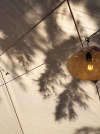Low angle view of illuminated lighting equipment hanging on ceiling