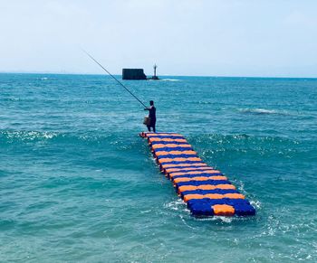 Man on boat in sea against sky