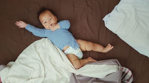 High angle view of baby boy lying on bed