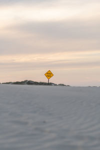 Dead end sign covered by sand at duskl