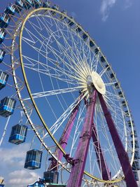 Low angle view of ferris wheel against blue sky