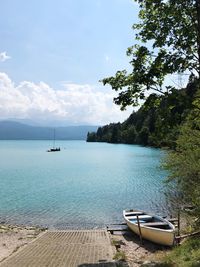 Sailboats moored on sea against sky