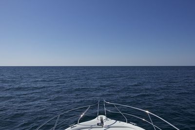 Sailboat sailing in sea against clear sky