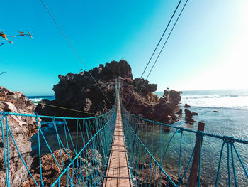 Low angle view of bridge over sea against clear sky