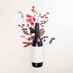 Composition with wine bottle and possible flavor components of red wine - berries, spices and other