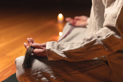 Cropped hand of woman holding lit candle