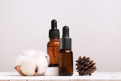Aromatherapy concept with essential oil bottle, cotton flower, pine cone. spa or organic cosmetic