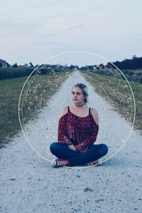 Digital composite image of woman sitting by constellation circle on footpath