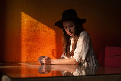 Portrait of young woman in hat sit alone in cafe