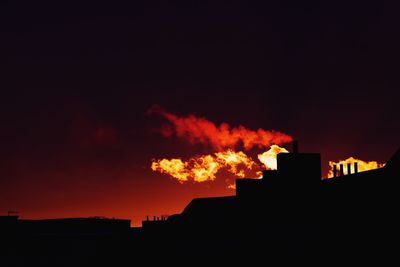 Silhouette buildings against sky at night