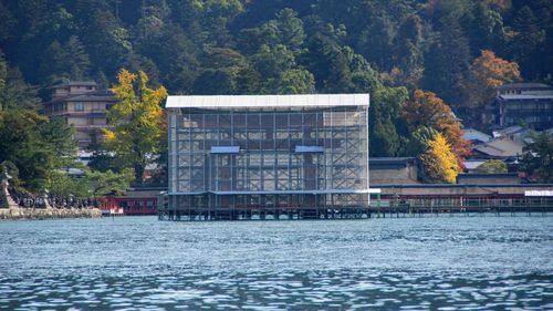 Building by lake against trees