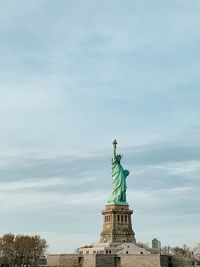 Low angle view of statue of liberty against sky