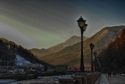 Street light on snow covered mountain against sky