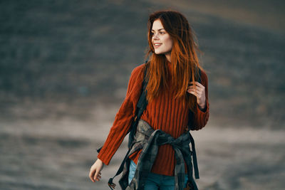 Young woman looking away while standing in sea