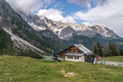 Houses on field by mountains against sky