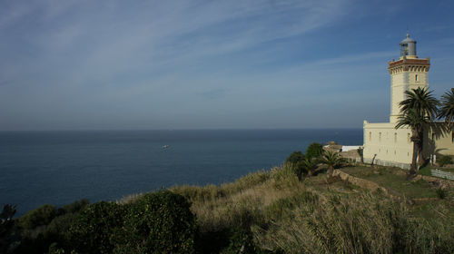 Lighthouse and sea against sky